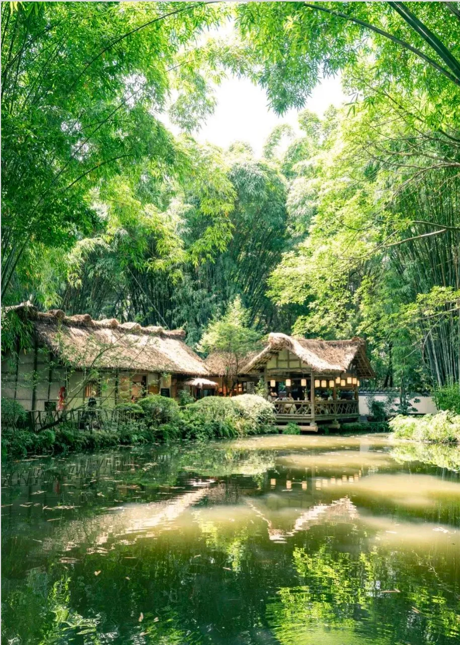 Thatched cottage pavilion reflected in a pond among bamboo at Dufu Cottage, Chengdu