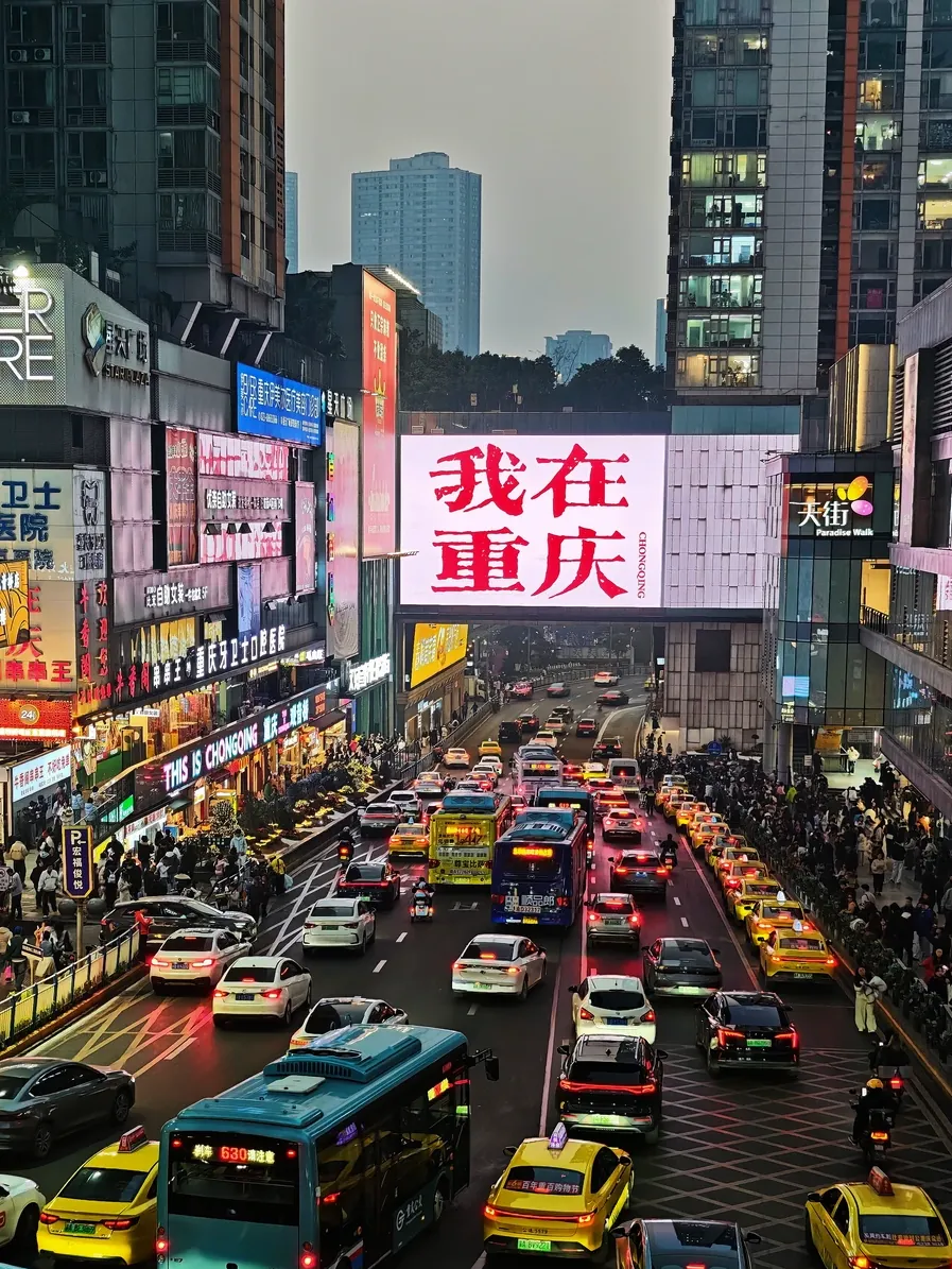 Guanyinqiao business district at dusk with the I-am-in-Chongqing billboard