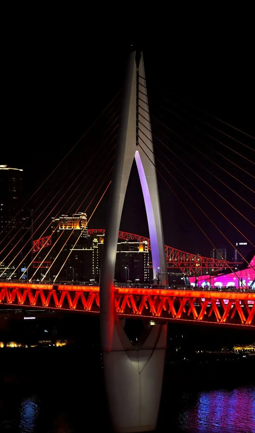 Qiansimen Bridge tower and red-lit deck over the Jialing River at night, Chongqing