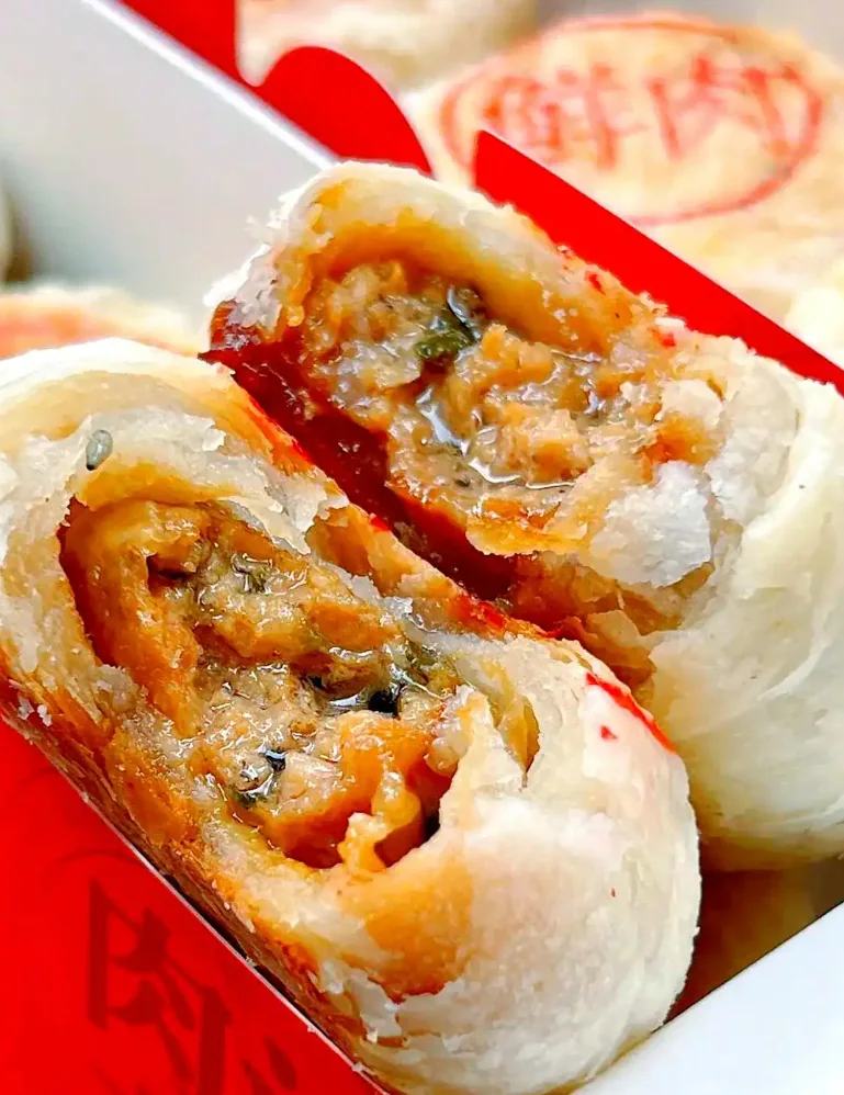 Fresh-meat mooncakes (xianrou yuebing) with flaky crust and a red stamp marking the pork filling, Shanghai
